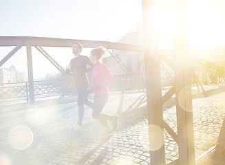 Image showing healthy young couple jogging in the city