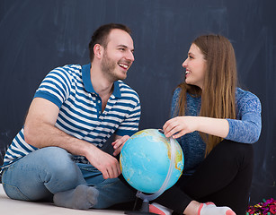 Image showing couple in casual clothing investigating globe