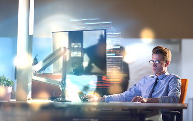 Image showing man working on computer in dark office