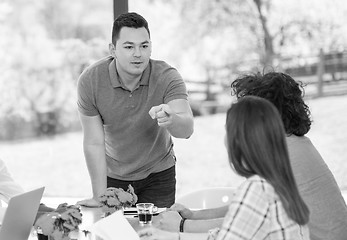 Image showing Young businessman with his team at work