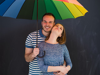 Image showing handsome couple with a colorful umbrella