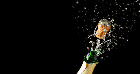 Image showing Opening bottle of champagne on empty black background