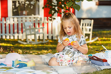 Image showing The little girl sitting on green grass