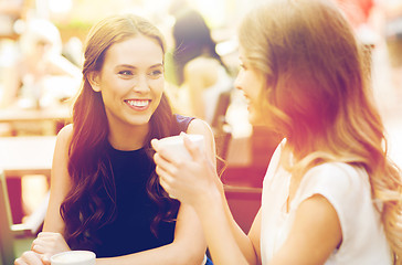 Image showing smiling young women with coffee cups at cafe