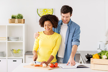 Image showing happy couple cooking food at home kitchen