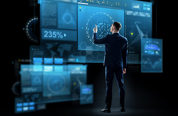 Image showing businessman in suit touching virtual screen