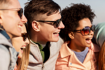 Image showing happy teenage friends in shades laughing outdoors