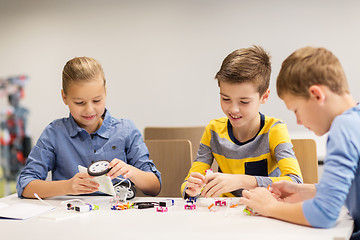 Image showing happy children building robots at robotics school