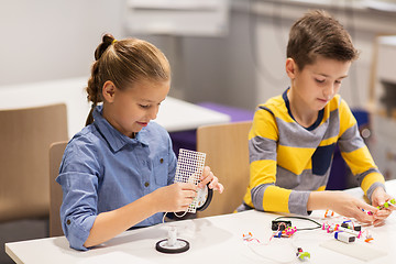 Image showing happy children building robots at robotics school