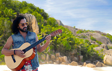 Image showing hippie man playing guitar over island beach