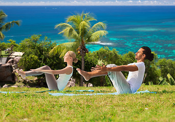 Image showing couple making yoga half-boat pose outdoors