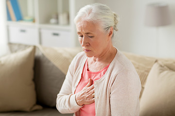 Image showing senior woman suffering from heartache at home