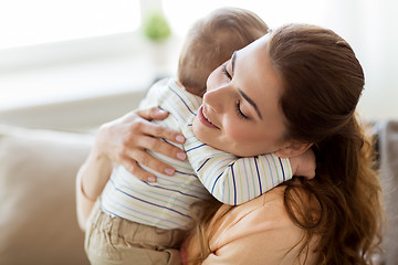 Image showing happy young mother hugging little baby at home