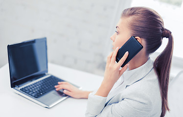 Image showing businesswoman with smartphone in office