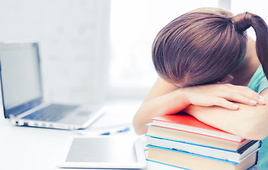 Image showing tired student sleeping on stock of books