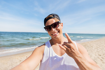 Image showing man in sunglasses taking selfie on summer beach