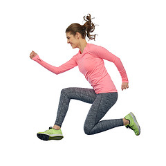 Image showing happy smiling sporty young woman jumping in air