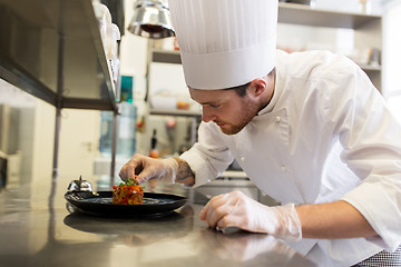 Image showing happy male chef cooking food at restaurant kitchen