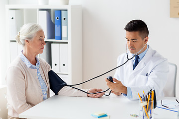 Image showing senior woman and doctor with tonometer at hospital