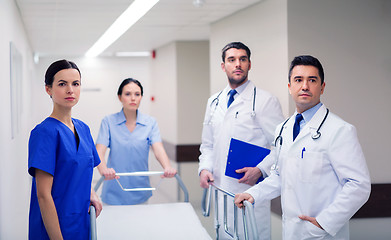 Image showing group of doctors with gurney at hospital