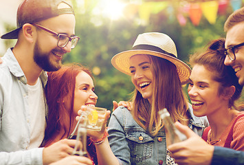 Image showing happy friends clinking glasses at summer garden