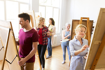 Image showing artists with brushes painting at art school