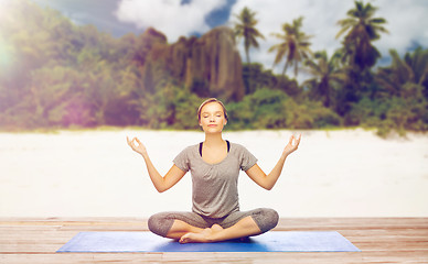 Image showing woman doing yoga meditation in lotus pose on beach