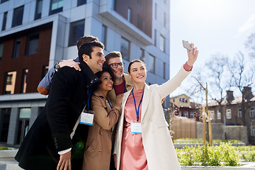 Image showing happy people with conference badges taking selfie