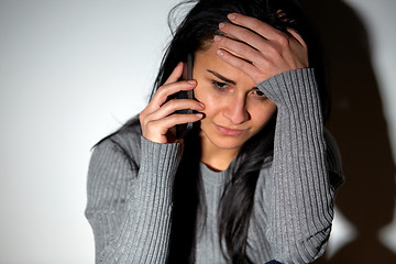 Image showing close up of crying woman calling on smartphone