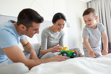 Image showing happy family in bed at home or hotel room