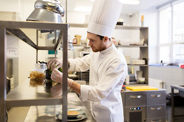 Image showing male chef cooking at restaurant kitchen