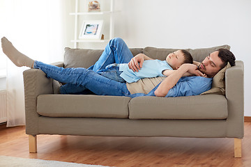 Image showing happy father and son sleeping on sofa at home