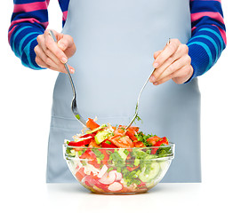 Image showing Cook is mixing salad