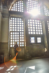 Image showing Silhouette of a woman on the window. Haze and sunlight beam