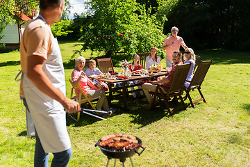 Image showing man cooking meat on barbecue grill at summer party