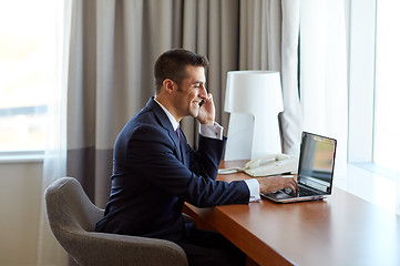 Image showing businessman with laptop and smartphone at hotel