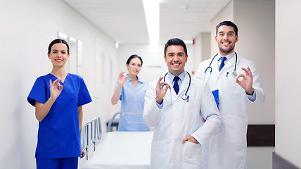 Image showing happy doctors with gurney showing ok at hospital