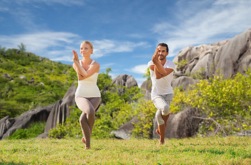 Image showing smiling couple making yoga exercises outdoors