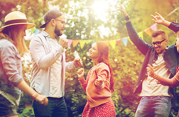 Image showing happy friends dancing at summer party in garden