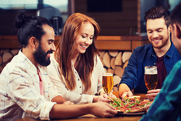 Image showing friends sharing pizza with beer at pizzeria