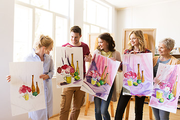 Image showing group of artists with pictures at art school