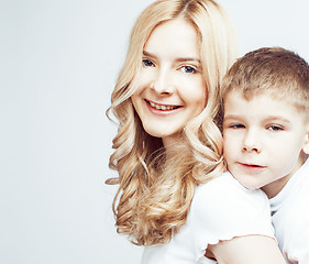 Image showing young modern blond curly mother with cute son together happy smiling family posing cheerful on white background, lifestyle people concept, sister and brother friends 