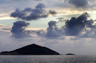 Image showing Island in sea and sky with dark clouds at sunset