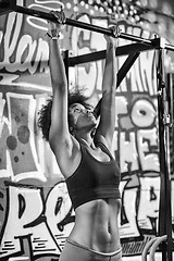 Image showing black woman doing pull ups