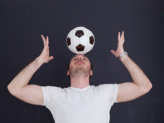 Image showing man playing with soccer ball isolated over grey