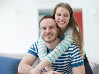 Image showing young handsome couple hugging on the sofa