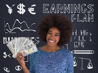 Image showing black woman holding money on gray background