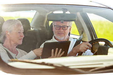 Image showing happy senior couple with tablet pc driving in car