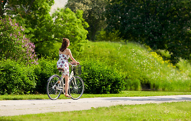 Image showing happy woman riding fixie bicycle in summer park