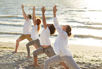 Image showing group of people making yoga exercises on beach